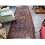 A middle Eastern hand-knotted wool carpet, navy ground, central row of multicoloured medallions,