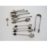 An assortment of Sterling and Continental silver teaspoons, coffee bean spoons, tourist example