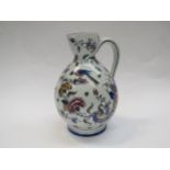 A Gien late 19th Century French Quimper wave jug with bird, butterfly and floral detail, 26cm tall