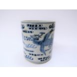 A blue and white Chinese brush pot decorated in an underglaze blue palette with chasing dragon,