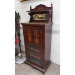 A Victorian rosewood music cabinet with mirrored shelved back over single door opening to reveal a