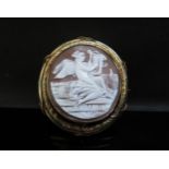 A large cameo brooch depicting a female playing the harp, 6.5cmx 6cm with a vacant glass panel back