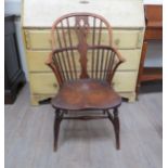 An 18th Century hoop back Windsor elbow chair, one stick missing, elm seated, H stretcher base