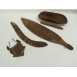 Five Aboriginal carved wooden items including a hunting boomerang and a woomera spear thrower