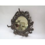 A Black Forest wall mirror with coat/hat hooks, carved with antlers, oak leaves and acorns, 38cm x