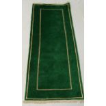 An emerald green ground wool runner, cream double order with fringing, made in Nepal together wit