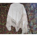 A late 19th/early 20th Century cream silk shawl, embroidered foliate design, deep fringing