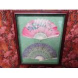 A mounted and framed display of two hand fans, one of fine gauze with hand-painted flowers in lilac,