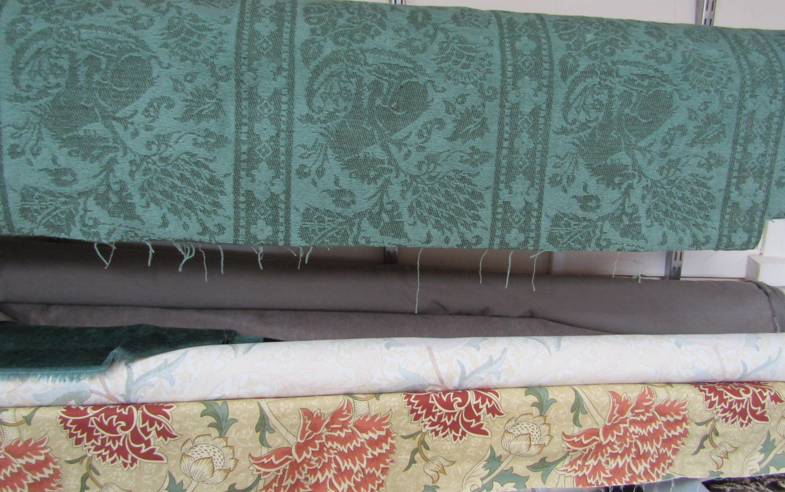Five bolts of furnishing fabric including green embossed velour depicting stylised lions, possibly