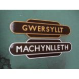 Two wooden painted reproduction station totems Machynlleth and Gwersylit