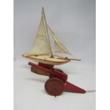 A vintage Star Yacht wooden pond yacht on stand, 40cm long, and a pressed tin artillery gun (2)