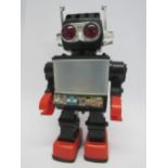 A 1980's plastic battery operated robot, finished in black, red and chrome, 32cm tall