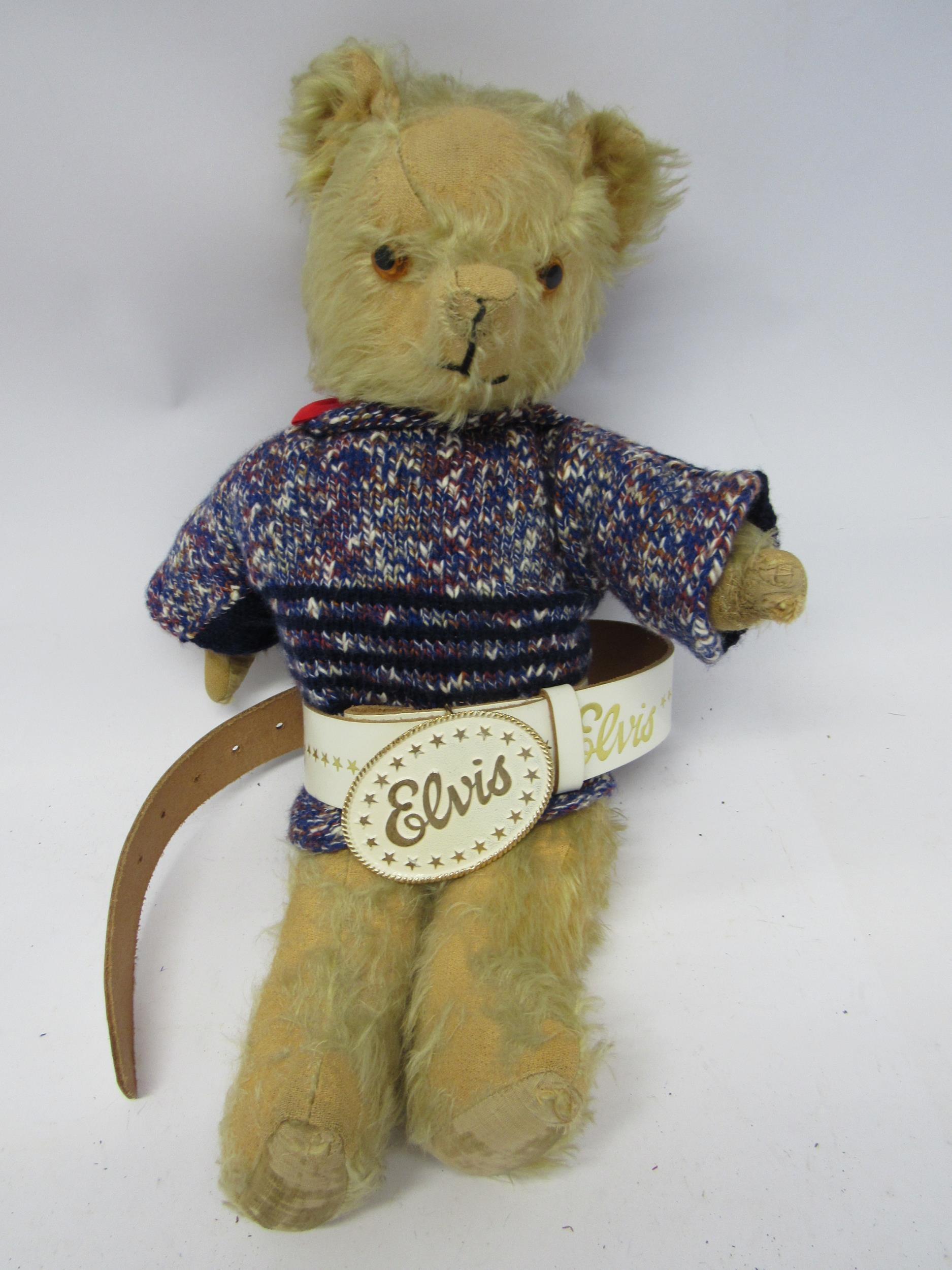 A mid 20th Century careworn golden mohair articulated teddy bear wearing knitted jumper and
