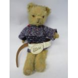 A mid 20th Century careworn golden mohair articulated teddy bear wearing knitted jumper and