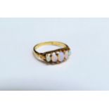 A gold ring set with five graduated oval opals, one damaged, marks rubbed. Size O, 3g