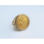 A gold ring with open scroll design set with a 1982 gold half sovereign, unmarked. Size T, 7.4g