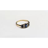 A sapphire and diamond ring, three oval sapphires spaced by two old cut diamonds, stamped 18ct. Size
