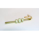 A gold bar brooch set with three opals, stamped 15ct, 6cm long, 3.9g