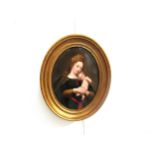 A gilt framed Berlin Porcelain oval plaque painted with a portrait of the Madonna and Child.