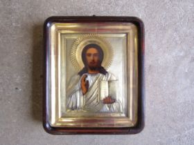A 19th Century Russian Icon, oil on board with gilded and silvered metal relief moulding, gilded