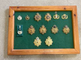 A board of Royal Marine Band helmet badges including Royal Yacht, Plymouth and Portsmouth divisions,