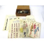 A wooden box containing vintage buttons, buttons on card and a small quantity of dressmaking