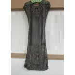 A 1920's black lace evening dress embellished with silvered embroidery and beading. The dress has