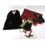 An early to mid 20th Century child's Scottish kilt jacket in black velvet, sporran, black wool