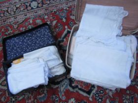 Two suitcases containing vintage table linens and huckaback towels