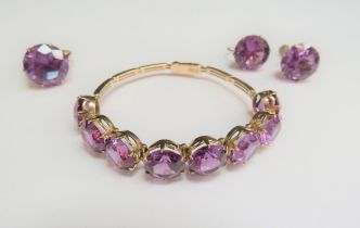 A gold line bracelet set with eight brilliant cut amethysts, stamped 14ct, 15.5cm long, matching