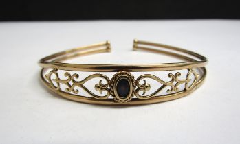 A 9ct gold open bangle with a single opal set in heart and scroll design, 5g
