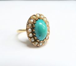 A gold turquoise and seed pearl ring, the central oval cabochon turquoise framed by seed pearls,