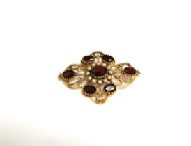 A 9ct gold brooch set with seven oval garnets with seed pearl decoration, 5cm x 3.5cm, 9.6g