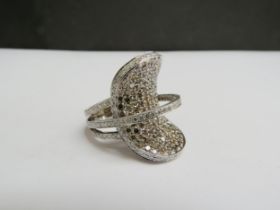 An 18ct white gold large diamond modernistic ring, the curved oval encrusted with cinnamon