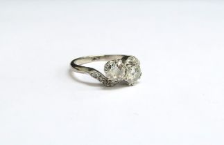 A diamond ring the two diamonds 1ct total approx with diamond set crossover shoulders, stamped 18ct.