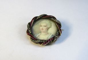 A 19th Century ruby and diamond framed miniature on ivory circular brooch depicting a female in blue