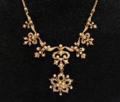 An Edwardian 15ct gold seed pearl necklace with a suspended detachable floral pendant/brooch,