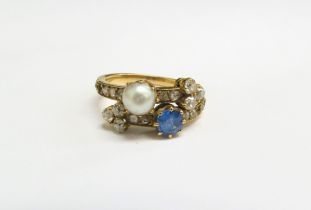 A gold ring with crossover bands of old cut diamonds, half pearl and blue stone, three small