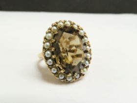 A 9ct gold ring, with large oval smoky quartz framed by seed pearls. Size M, 9.8g