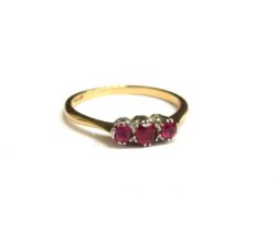 An 18ct gold platinum set ring with three small rubies. Size P, 2.1g