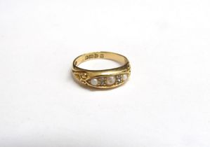 An 18ct gold ring set with three pearls spaced by two old cut diamonds (centre pearl has damage to