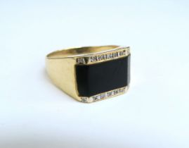 A gent's gold ring with black onyx front edged with diamonds, stamped 14k. Size Z3, 7.4g