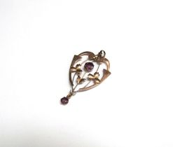 An Edwardian gold pendant set with amethyst coloured stones, stamped 9ct, 5cm long, 1.8g