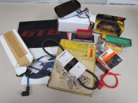 A box containing car spares including NGK spark plugs, a Haynes manual for a 1959-1978 Mini, a