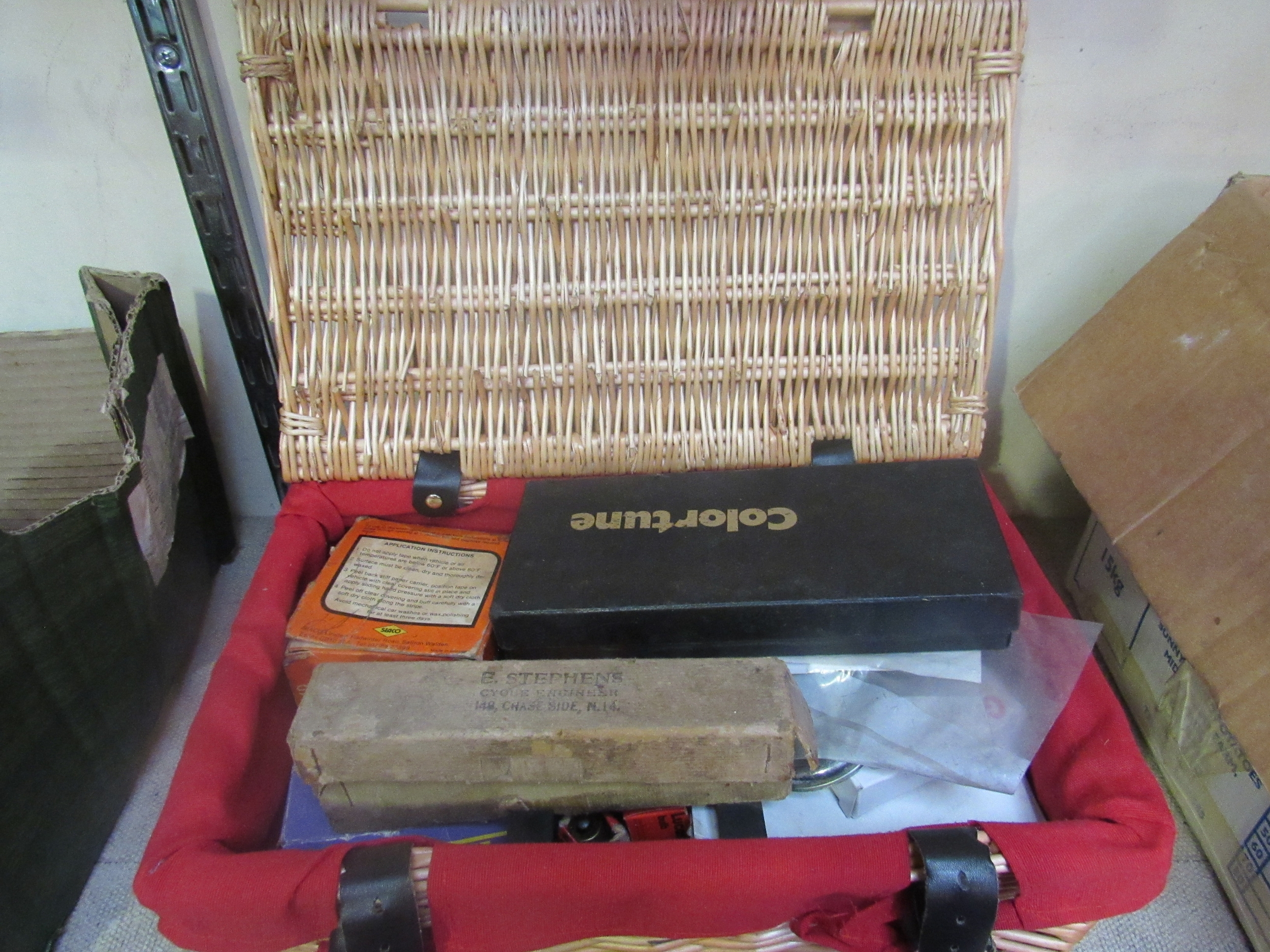 A wicker hamper containing mixed bike spares etc. including bulbs and inner tubes