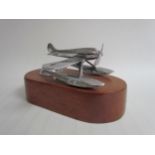 A chromed mascot of a float plane mounted on a timber plinth