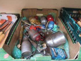 A box of oil cans and two brass grease guns