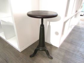 An industrial cast iron stool with circular wooden seat on corkscrew adjusting base. Unmarked.