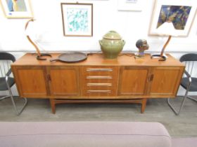 A mid century G-Plan Fresco teak sideboard, four drawer centre flanked by two pairs of cupboard