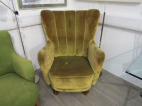 A 1940's Danish high backed armchair, original green upholstery and raised on thick stained hardwood